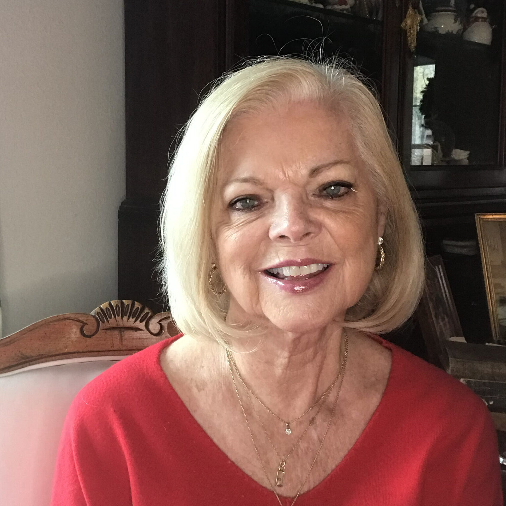 Smiling woman wearing a red sweater.