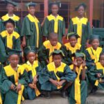 Students in graduation robes smiling.