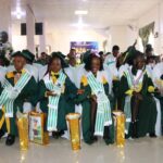 Children in graduation gowns with gifts.