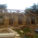 Unfinished building with wooden beams and brick walls.